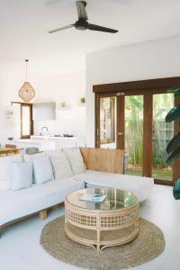 a living room with a white couch and a coffee table at Three Palms Surf & Stay Medewi in Airsatang