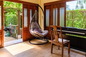 una veranda con sedia a dondolo e pianoforte di Garden Cottage by Utalay Koh Chang a Ban Khlong Son