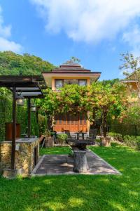 una casa con un tavolo da picnic nell'erba di Garden Cottage by Utalay Koh Chang a Ban Khlong Son