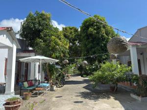 a patio of a house with chairs and an umbrella at Eden House & Coffee Con Dao in Con Dao