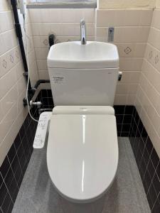 a white toilet in a bathroom with a sink at penthouse半田 in Handa +9 photos