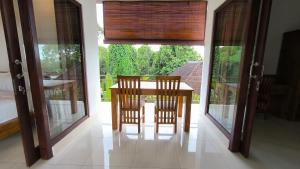a dining room with a table and two chairs on a balcony at Dharma Suweta in Ubud