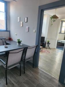 een eetkamer met een tafel en stoelen in een kamer bij Laelia place Rivotte in Besançon