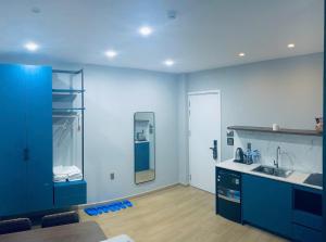 a kitchen with blue cabinets and a sink and a mirror at Lapit Hotel And Apartment in Da Lat