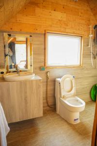 a small bathroom with a toilet and a sink at Tropangsneh Dakdam Resort in Phumĭ Pu Ântrêng (1)