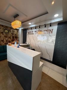 una hall con un bancone della reception e un cartello di Hotel Hill Top Inn -Near Baner Rd Pune a Pune