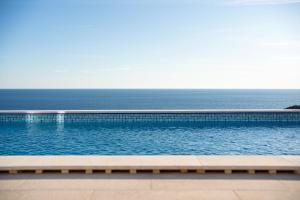 a swimming pool with the ocean in the background at Villa Maris in Lustica