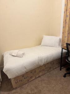 - un lit avec des draps blancs et un oreiller dans l'établissement Haymarket Centro , Flat familiar quarto privativo banheiro compartilhado, à Édimbourg