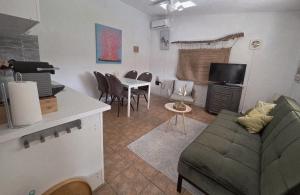 Una sala de estar con un sofá y una mesa con sillas. en Casita Cártama casa rural jacuzzi, en Estación de Cártama