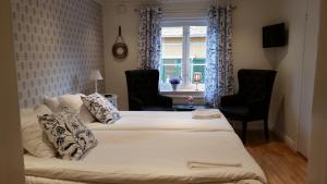 1 Schlafzimmer mit 2 Betten, 2 Stühlen und einem Fenster in der Unterkunft Pensionat Ankargården in Öregrund