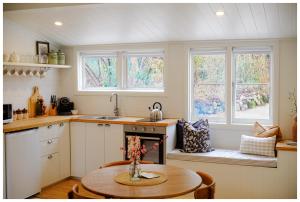 a kitchen with a table and some windows at Garden View Cottage in Stanley