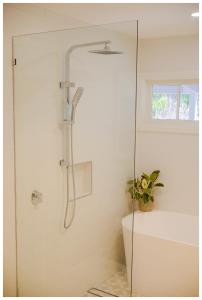 une douche avec une porte vitrée dans une salle de bain dans l'établissement Garden View Cottage, à Stanley