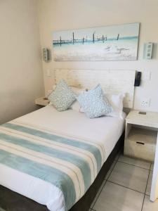 een slaapkamer met een bed met een schilderij aan de muur bij Banana Beach B4 in Melville +39 foto's