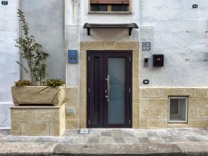 a black door on a building with a potted plant at Sus e Sott B&B in Mottola