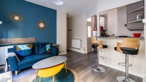salon z niebieską kanapą i stołem w obiekcie L'Escapade Urbaine - Cosy et central w mieście Dijon