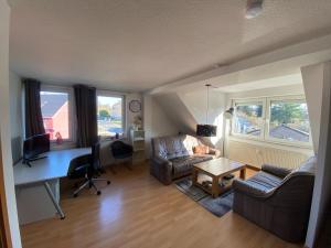a living room with a couch and a desk at Cozy studio apartment in Hohenmölsen