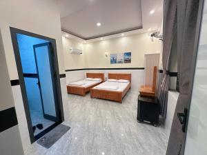 a room with two beds and a mirror at Nhà Nghỉ Phát Lợi in Quy Nhon +16 photos