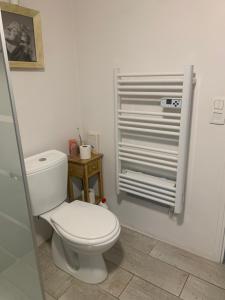 une salle de bain avec des toilettes blanches et un radiateur dans l'établissement Havre de Paix, à Villeneuve-sur-Lot