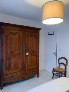 - une chambre avec une grande armoire en bois et une chaise dans l'établissement Havre de Paix, à Villeneuve-sur-Lot