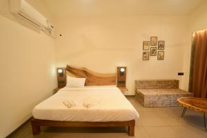 Mountain Woods Farmstay, Khopoli Pure Veg في خوبولي: غرفة نوم بها سرير وأريكة
