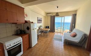 a kitchen with a refrigerator and a table with a chair at Pelagos Apartments in Myrtos