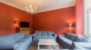 a living room with red walls and blue couches at Gite la Blanche in Ogy