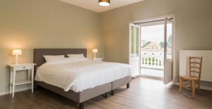 a bedroom with a bed and a large window at Gite la Blanche in Ogy