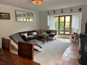 a living room with a couch and a table at Apartment BERGfamilie - gemütlich ausgestattet, ruhig und familienfreundlich in Schliersee
