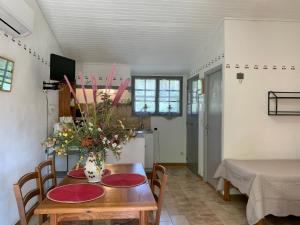jadalnia ze stołem i wazonem kwiatów w obiekcie Gîte La loge 142 route de CARPENTRAS 84210 VENASQUE w mieście Venasque