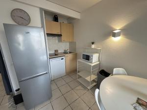 a kitchen with a refrigerator and a clock on the wall at Résidence Graziella Studio 308 in Juan-les-Pins