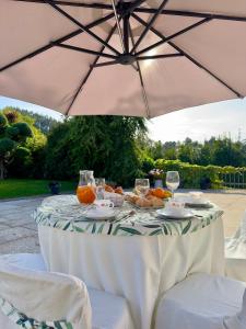 einen Tisch mit einem Regenschirm und ein paar Drinks darauf in der Unterkunft Vibrant Host Solutions-Aldeia da Graça in Guimarães