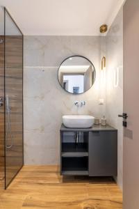 een badkamer met een wastafel en een spiegel bij Lume, Stylish New Apartment Near the Beach in Agia Pelagia