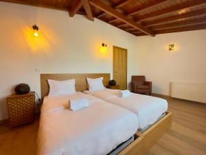 zwei Betten in einem Zimmer mit weißen Laken in der Unterkunft Vibrant Host Solutions-Aldeia da Graça in Guimarães + 82 Fotos