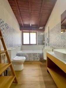 ein Badezimmer mit Badewanne, Toilette und Waschbecken in der Unterkunft Vibrant Host Solutions-Aldeia da Graça in Guimarães