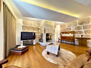 ein Wohnzimmer mit einer großen Steinmauer in der Unterkunft Vibrant Host Solutions-Aldeia da Graça in Guimarães