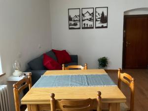 ein Tisch und Stühle in einem Wohnzimmer mit einer Couch in der Unterkunft Ciasa Larese, between the lake and the Dolomites in Auronzo di Cadore + 4 Fotos