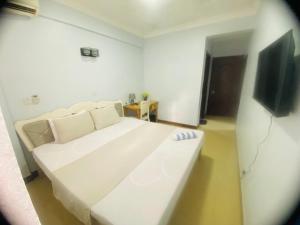 a white couch in a room with a tv at Skylar H & Apartment in Dar es Salaam