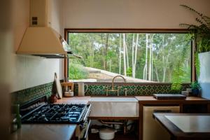 a kitchen with a sink and a large window at Off-Grid Eco Cabin in Bellingen +7 photos