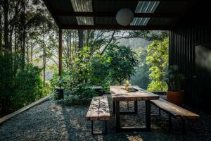 a table and benches in a room with a view at Off-Grid Eco Cabin in Bellingen