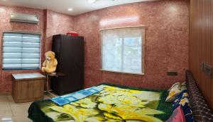 a bedroom with a bed and a teddy bear sitting on a table at Casa De Nazareth Homestay in Cochin