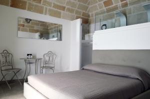 een slaapkamer met een bed, een tafel en stoelen bij Matilde Home in Monopoli