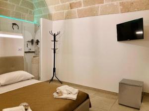 een slaapkamer met een bed en een tv aan de muur bij Matilde Home in Monopoli
