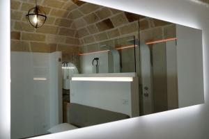 een badkamer met een witte wastafel en een spiegel bij Matilde Home in Monopoli