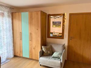 a living room with a chair and a mirror at Ferienwohnung Bergleuchten in Obermaiselstein