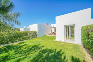 a white house with a green yard at HideAway by MOJE Holiday in Porches