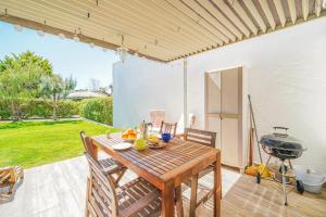 a patio with a wooden table and a grill at HideAway by MOJE Holiday in Porches