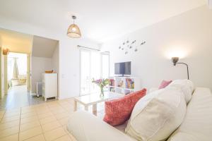 a living room with a white couch and a table at HideAway by MOJE Holiday in Porches