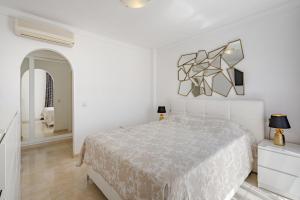 a white bedroom with a bed and a mirror at Townhouse Park Paraiso in Adeje +15 photos