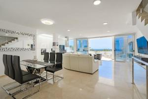 a living room with a couch and a table and chairs at Townhouse Park Paraiso in Adeje