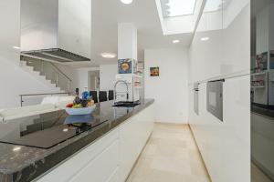 a white kitchen with a bowl of fruit on a counter at Townhouse Park Paraiso in Adeje